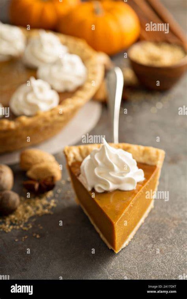 Pumpkin Pie topped with whipped cream and pecan sauce.