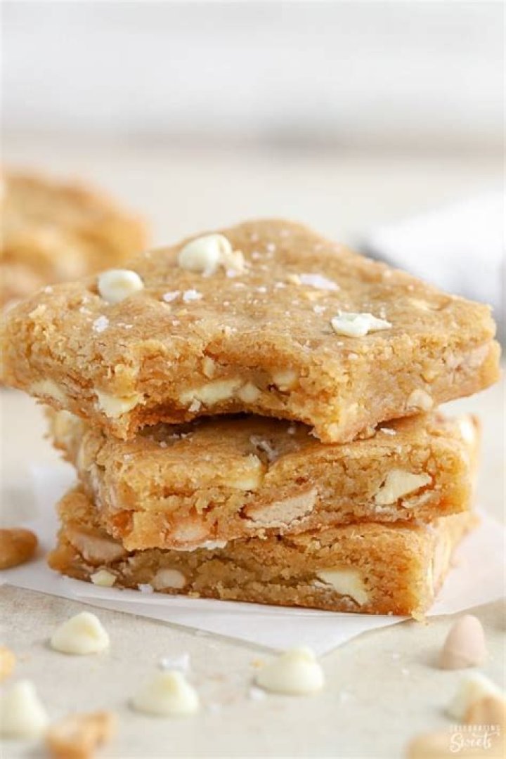Stack of three blondie bars on parchment paper.